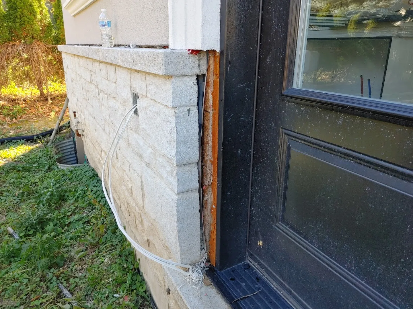 Exterior water drainage pipe connection showing deterioration on residential foundation