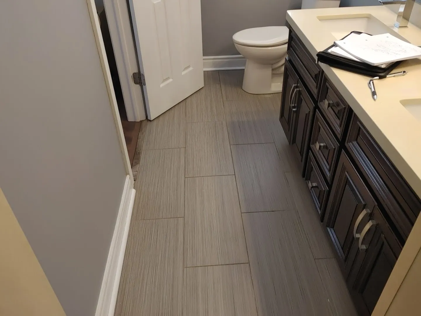 Completed bathroom renovation with new flooring, fixtures, and finishes after water damage repair