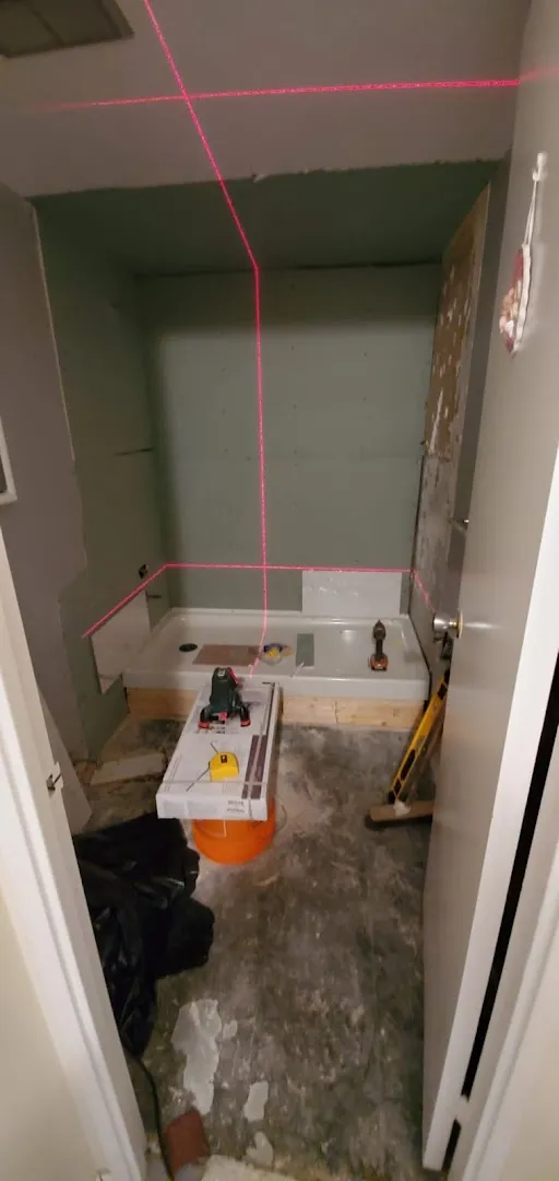Bathroom undergoing water damage assessment with laser measurement marking walls and flooring