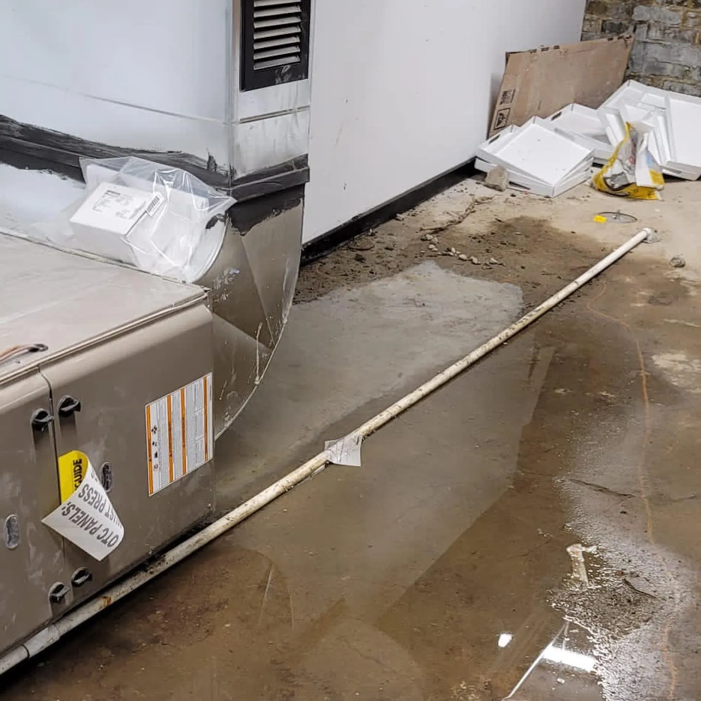 Outdoor water damage restoration site with mobile dehumidification trailer and water extraction equipment setup