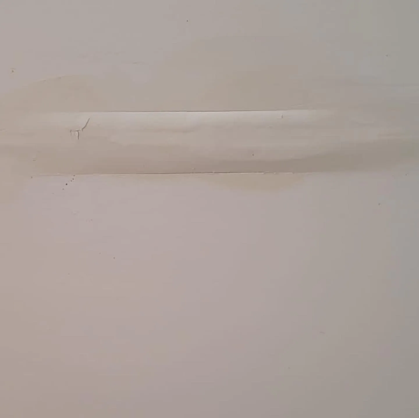 Drywall ceiling with horizontal water damage line marking flood extent