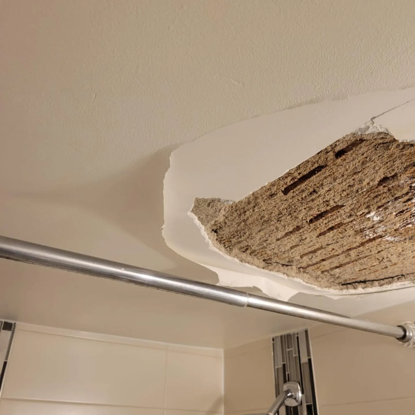 Wall corner showing water damage stains with brown discoloration and deterioration at baseboard